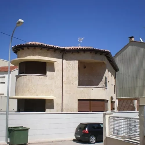 Vista de vivienda unifamiliar desde la calle con canalón instalado