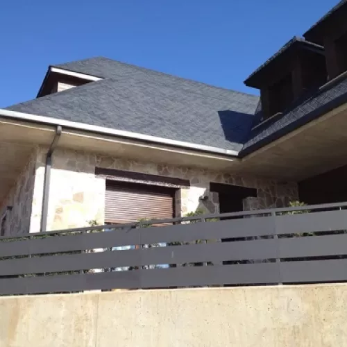 Vista de canalón instalado en vivienda unipersonal con techo de pizarra