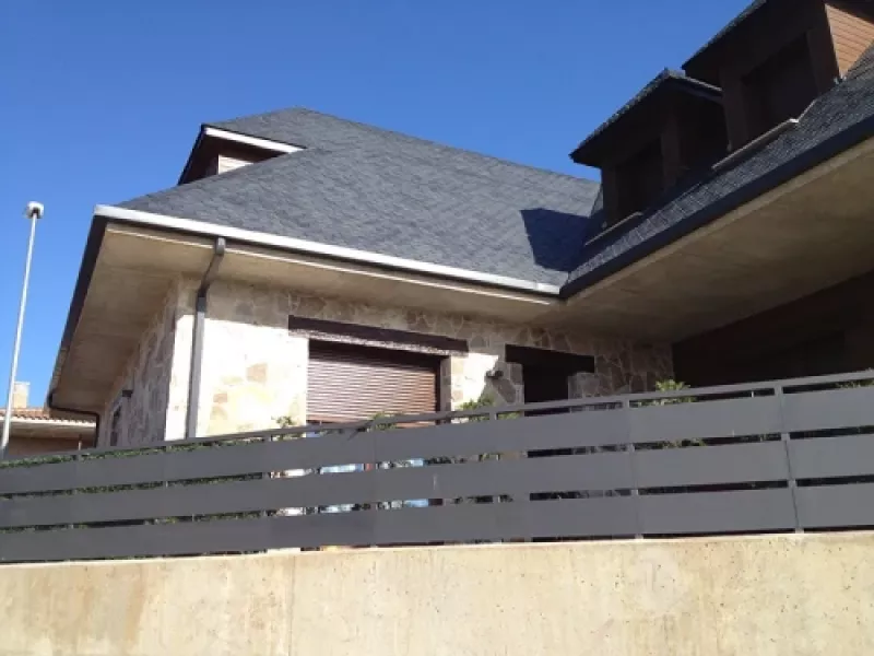 Vista de canalón instalado en vivienda unipersonal con techo de pizarra