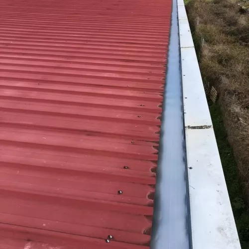 Tejado metálico rojo con canalización lateral